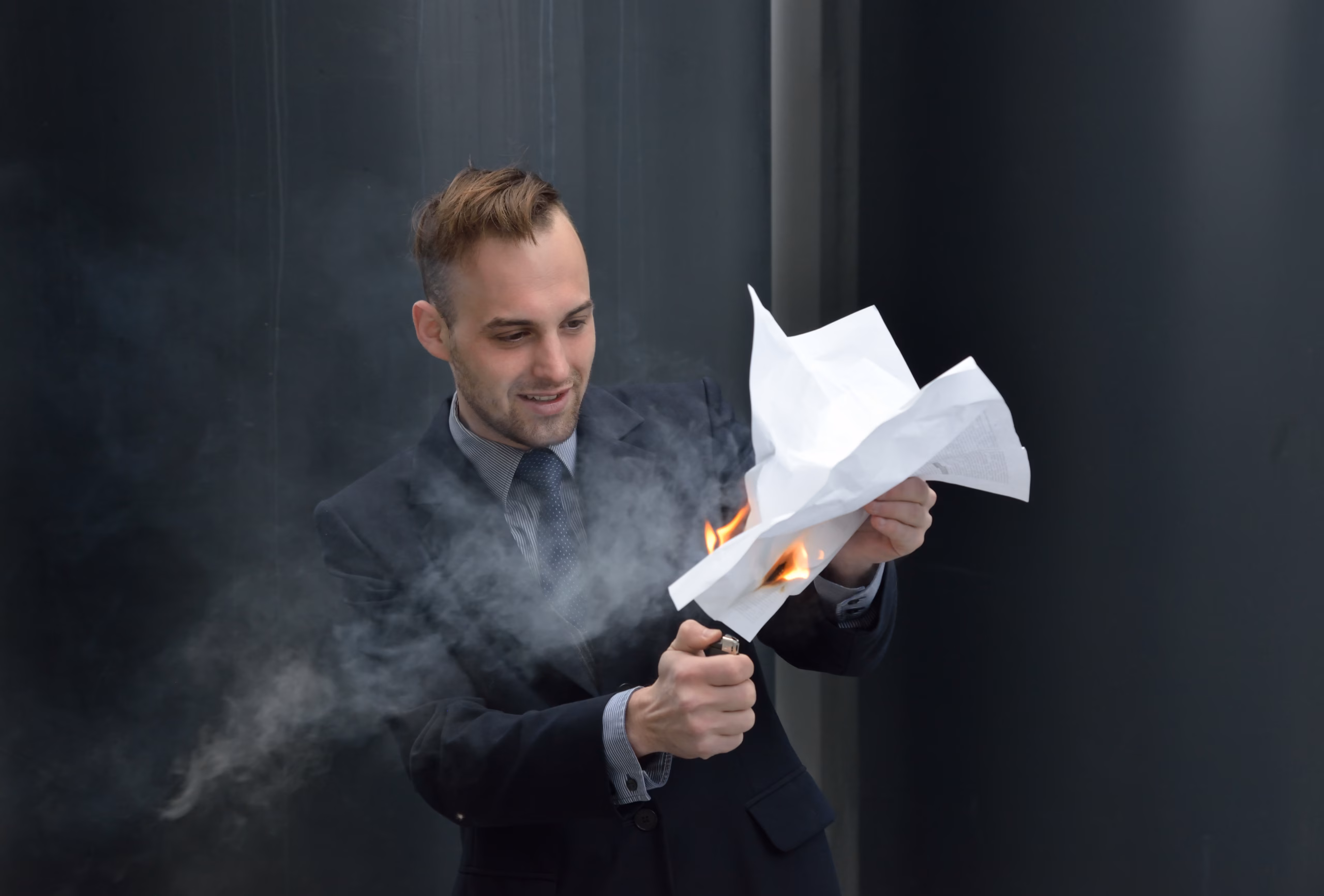 Man burning a written contract to represent a contract dispute or breach of agreement